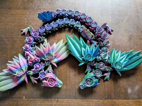 May include: A collection of colorful, handcrafted floral and succulent-themed decorative pieces. The pieces feature a variety of pastel colors, including pink, blue, and green, with intricate details. The arrangement includes rose and succulent designs.